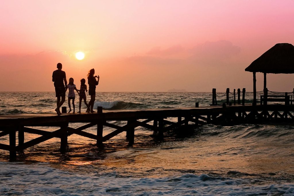 Stehende Menschen auf dem Dock bei Sonnenaufgang