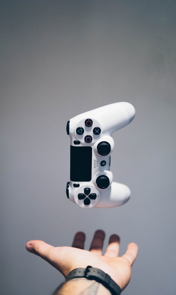 weißer Sony PS4 DualShock-Controller über der Handfläche der Person